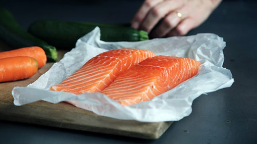 Raw fish placed on top of parchment paper