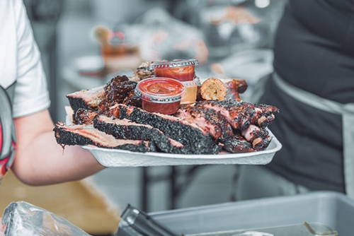 person holding smoked brisket