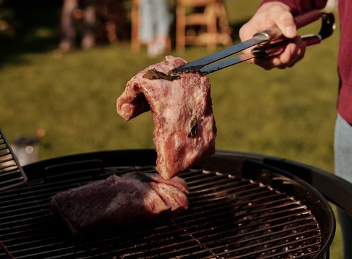 closeup of a person grilling steak