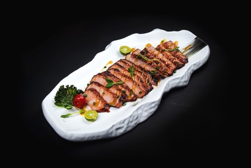 Lemon dressed grilled meat on white plate