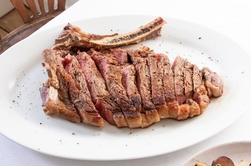 Appetizing cut ribeye steak served on restaurant table