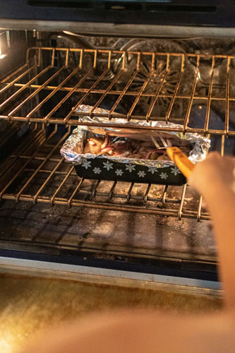 Person Taking Grilled Meat From The Oven