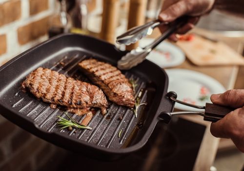 Frying Pan with Grilled Steaks and Rosemary
