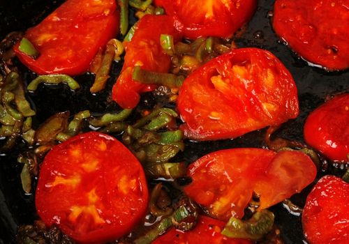 Sliced Tomatoes and Sweet Peppers are Fried in a Pan