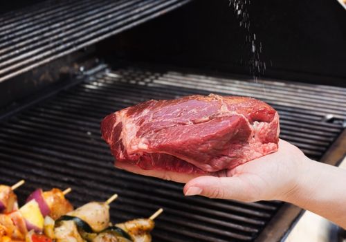 Woman Placing the Steak on the Grill