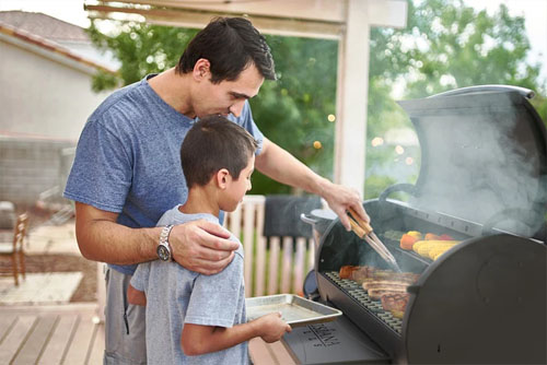 Father and Son Grilling Meat Using Louisiana Grills