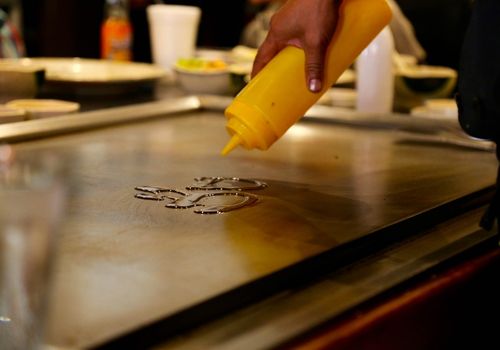 Person Pouring Oil on a Griddle