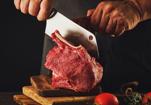 Male Butcher Cuts Raw Beef Meat