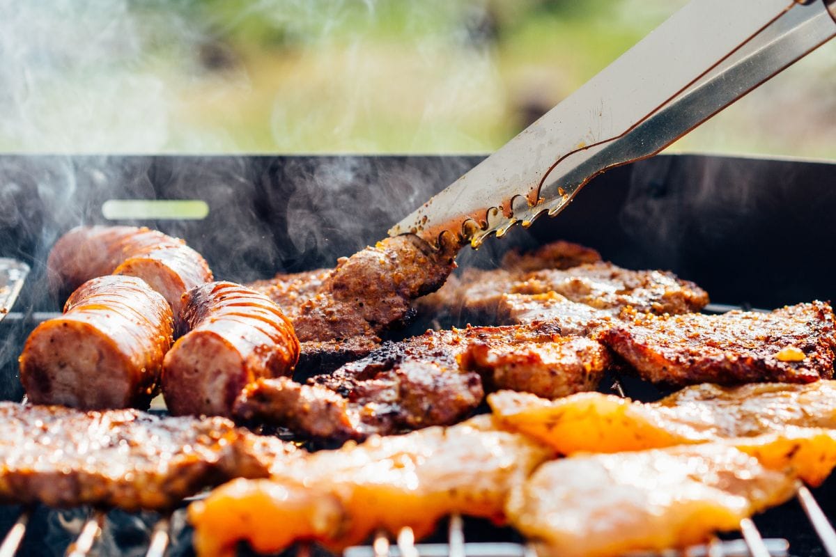 Barbecuing Meat and Sausages on an Outdoor Grill