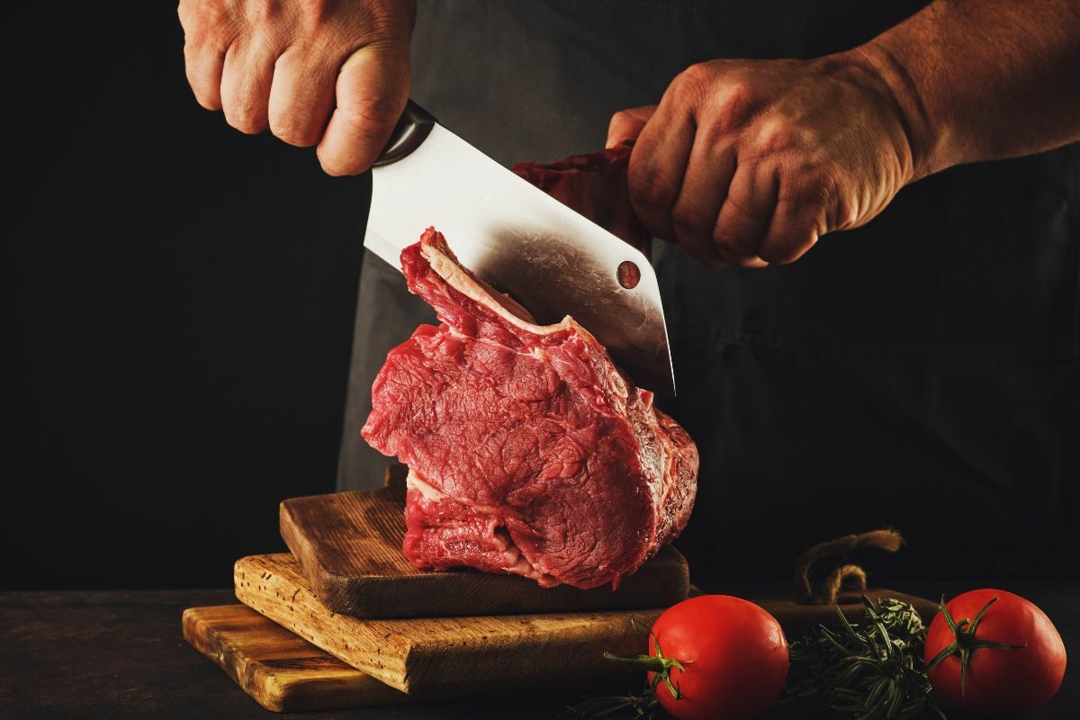 Male Butcher Cutting Raw Beef Meat