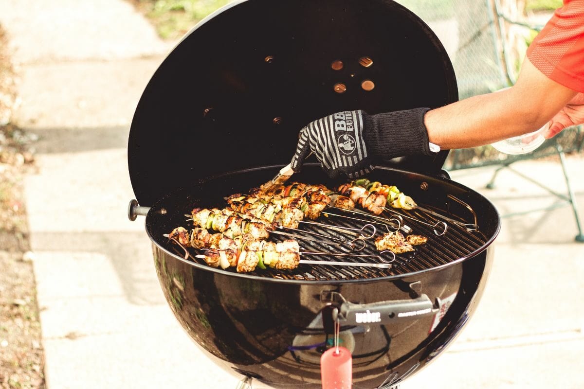 Person Grilling Skewers on the Charcoal Grill